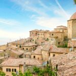 Panorama delle colline toscane con borghi caratteristici e paesaggi verdi, simbolo di viaggi economici nel 2025.