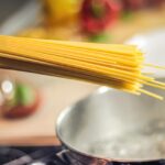 Acqua di cottura della pasta in un contenitore, pronta per innaffiare piante.