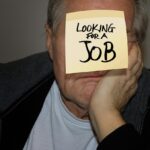 Uomo con sedia a rotelle in un ufficio, simbolo della pensione anticipata per invalidi civili.