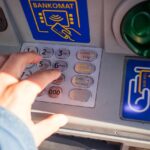 Bancomat con evidenziato il numero di prelievi, simbolo di limitazioni mensili.