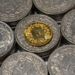 Moneta da 5 lire italiana, valore stimato fino a 15 mila euro, in primo piano su sfondo neutro.