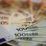 Immagine di un conto in banca con saldo superiore a 10.000 euro e simboli di nuove regole finanziarie.